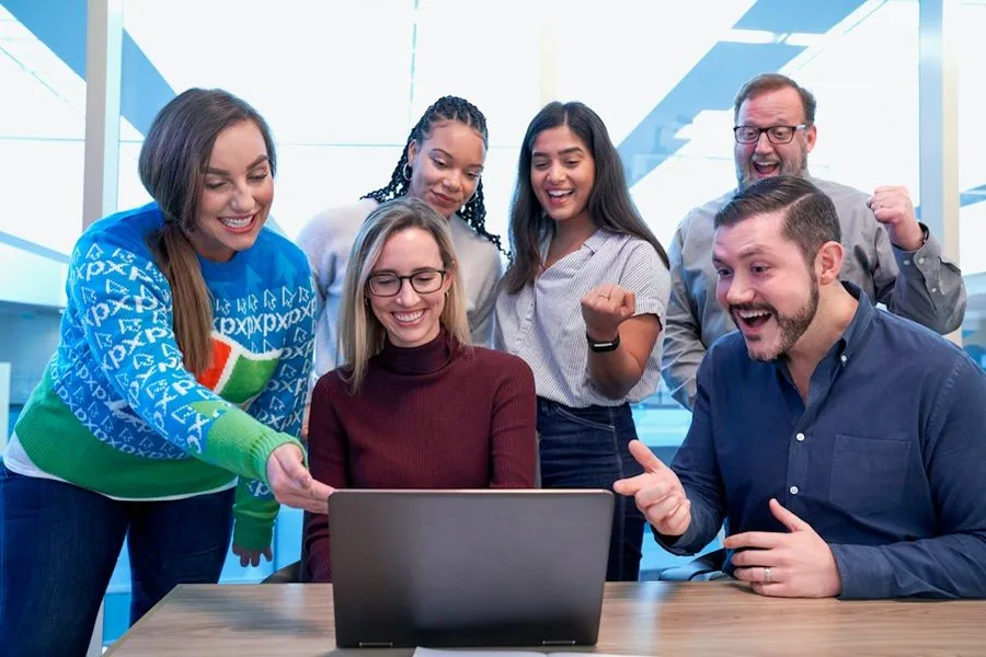 Équipe de participants réunie autour d’un ordinateur portable pendant une formation