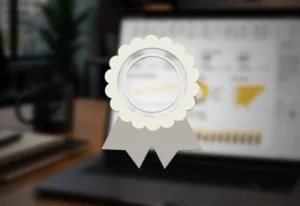 vignette-secondary | Formation Power Bi, AWS, Excel, VBA, Linux, Quickbook, InDesign Silver award badge icon over a blurred laptop screen, signaling certification or achievement.